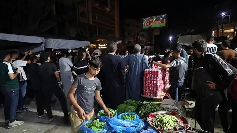 Torcedores palestinos assistindo à partida do Grupo G da Copa do Mundo entre Bélgica e Egito em um telão montado no campo de refugiados de Nuseirat, no centro de Gaza, em 15 de junho de 2026.