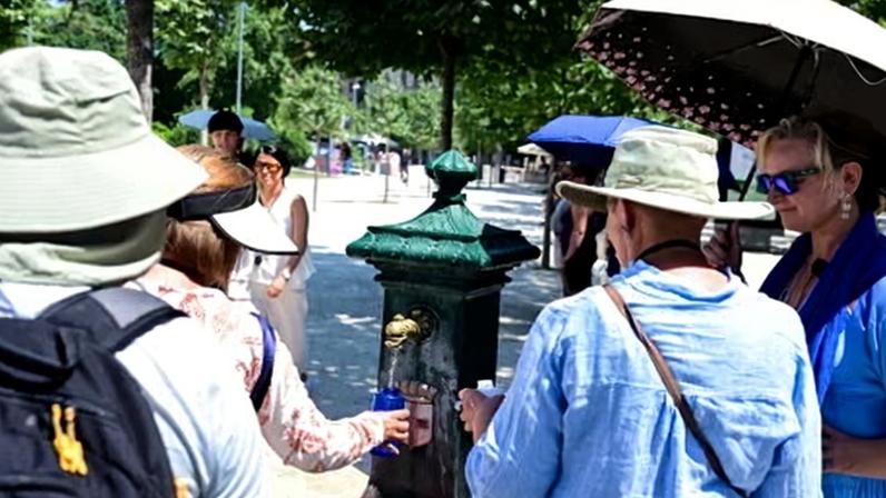 People cool themselves at a public fountain during a heatwave in Milan, Italy on June 21, 2026.