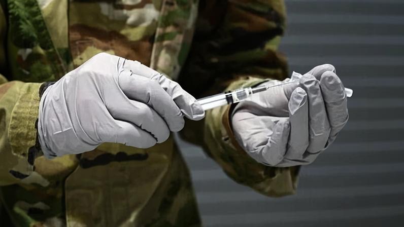 An aerospace medical technician prepares a flu vaccine in California in 2022.