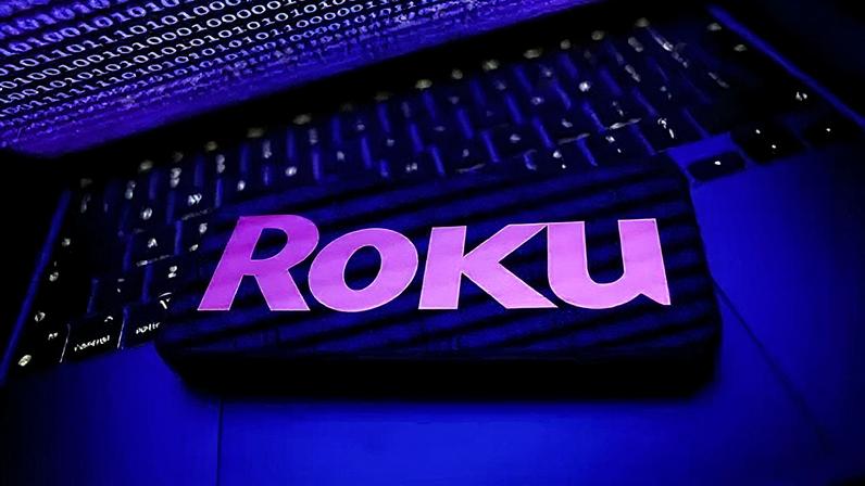NurPhoto via Getty Images Binary code displayed on a laptop screen and Roku logo displayed on a phone screen