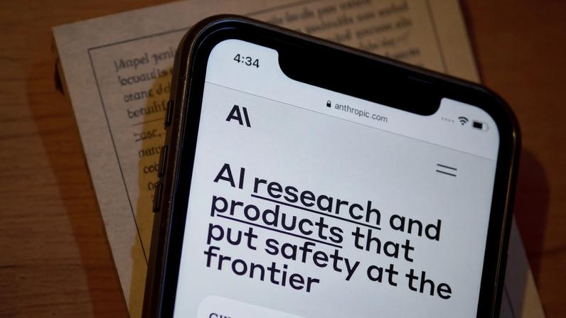 Tela de smartphone exibe site da Anthropic com texto 'AI research and products that put safety at the frontier'.