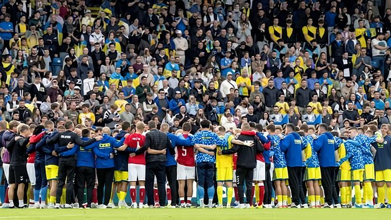 Denmark and Ukraine players gather in a huddle after Christian Eriksen had been taken away in an ambulance from Odense Stadium on Sunday.