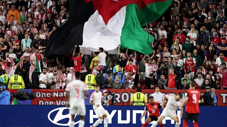 Bandeira da Jordânia sendo exposta pela torcida durante partida contra a Áustria, pela primeira rodada da Copa do Mundo