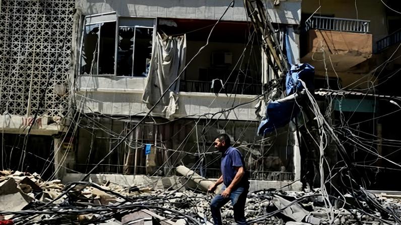 A man walks through rubble after an Israeli strike in Tyre, Lebanon, 12 June 2026.