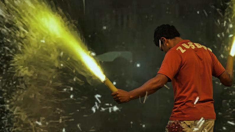 Homem brincando com fogos nos festejos juninos.