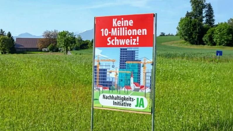 An SVP campaign sign in a field in the canton of Zurich. It reads: ‘No Switzerland with 10 million. Yes to the sustainability initiative.’ Photograph: Denis Balibouse/Reuters