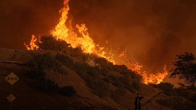A firefighter battles the Palisades Fire in Mandeville Canyon, 11 Jan 2025, in Los Angeles.
