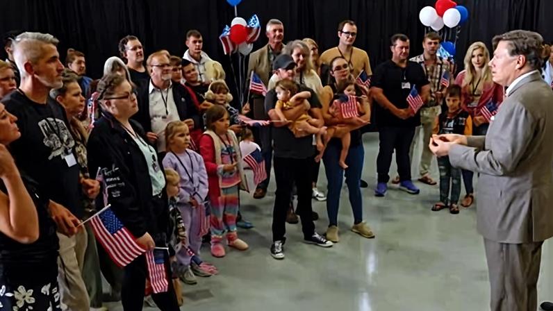 Newly arrived South Africans listen to the US deputy secretary of state, Christopher Landau, in a Washington aircraft hangar on 12 May 2025.