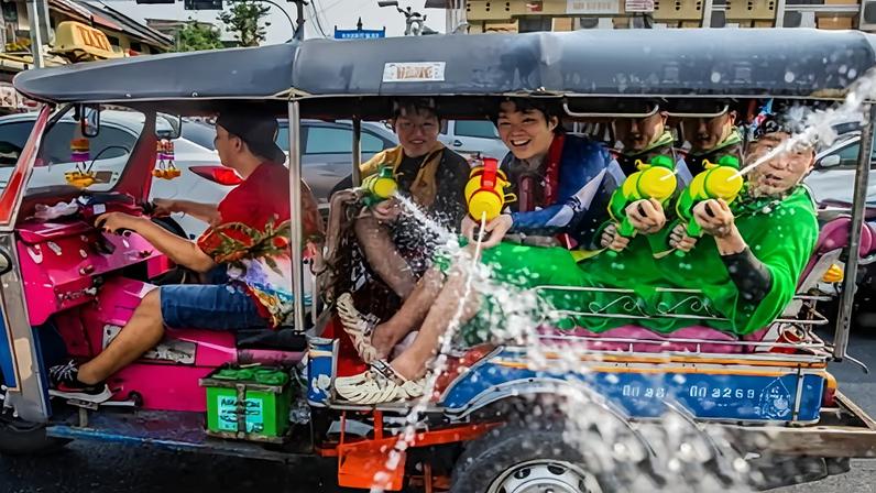 Tourists spray water guns out of a tuk tuk on Khaosan Road during the Songkran festival on 13 April, 2023 in Bangkok, Thailand.