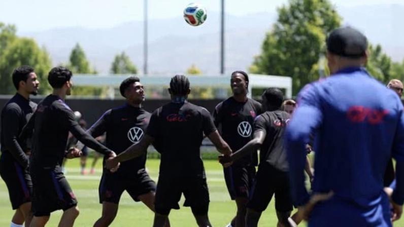 Team USA players in black training gear watch a ball in the air during a training session