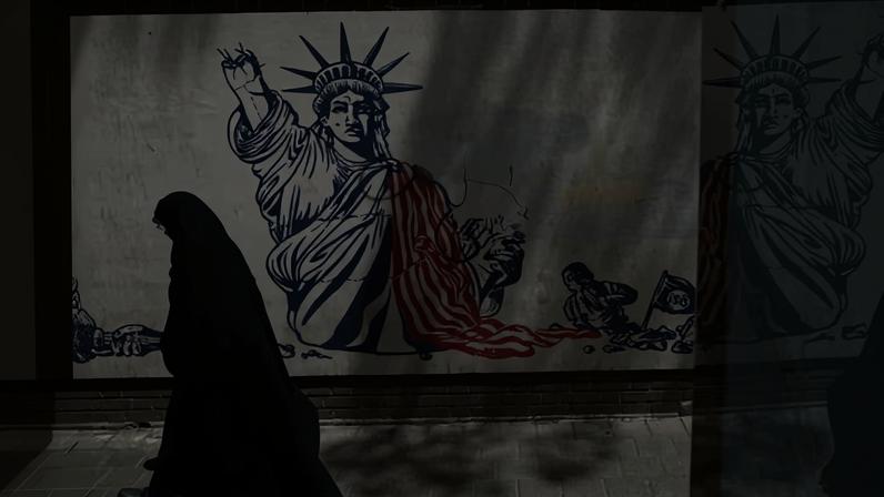 A woman walking past an anti-US mural on a street in Tehran, 1 June 2026.