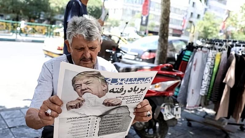 A man reads the Iranian daily newspaper Hamshahri bearing an image of the US president and a headline that reads "Gone with the wind". Tehran, June 18, 2026.