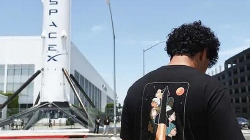 Getty Images A man shown from behind looking at his phone outside the Space Exploration Technologies Corp. facility in Hawthorne, California,
