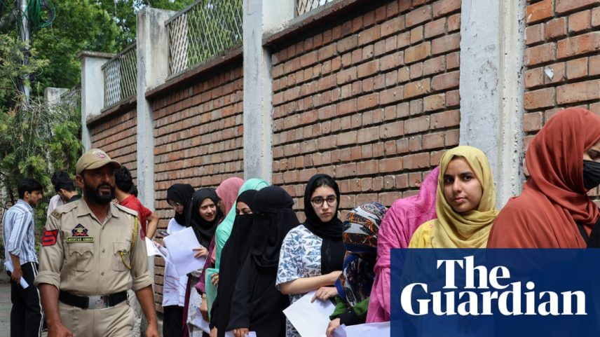 An Indian policeman patrols as candidates wait to enter an examination centre for the re-examination in Srinagar, Jammu and Kashmir, on 21 June 21 2026.