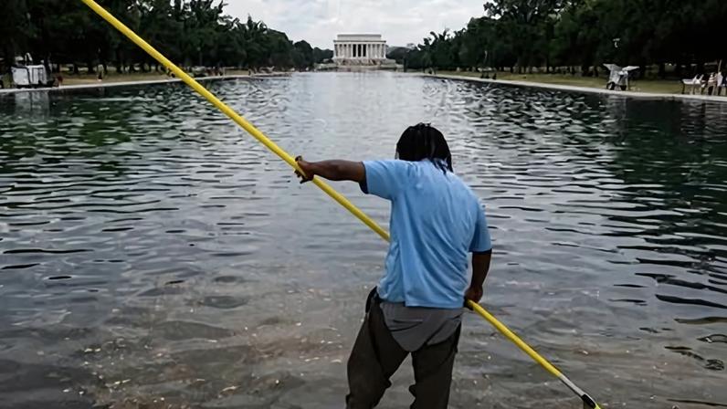 A worker cleans the waters of the Lincoln Memorial Reflecting Pool following the completion of recent renovations in Washington DC on 22 June.