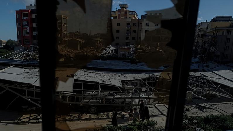 People walk past rubble at the site of an Israeli strike following a deal between the US and Iran