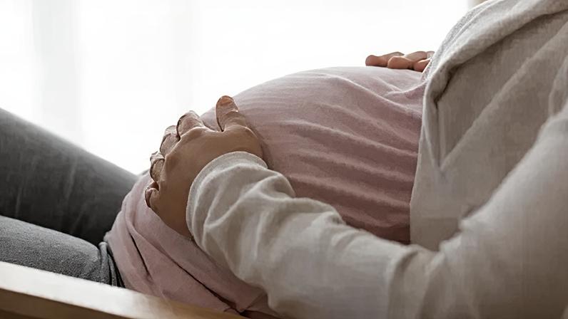 Getty Images A stock image of an expectant mother touching her baby bump.