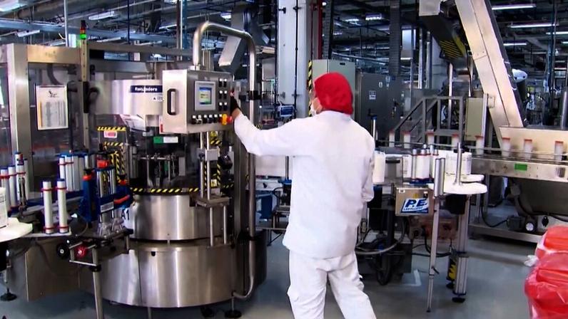 Pessoa operando máquina industrial em linha de produção automatizada