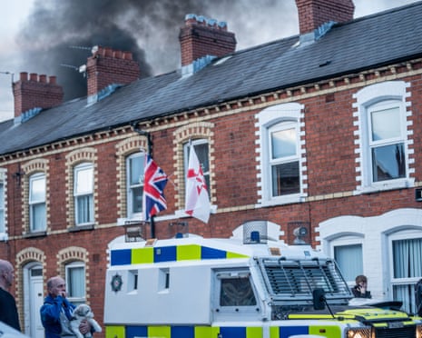 Riot police arrive at the scene of a fire lit by anti-immigration protesters in Belfast.