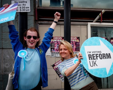 Young Reform UK supporters wave placards to motorists in Makerfield on Thursday.