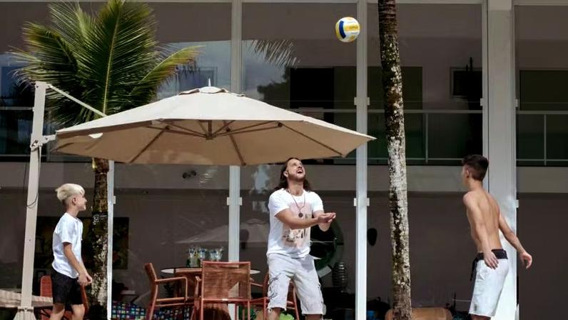 RETRATO | Tato está na área externa brincando com os filhos Gael e Ravim. Atrás, os grandes panos de vidro da fachada da casa garantem conexão visual entre os ambientes internos e externos