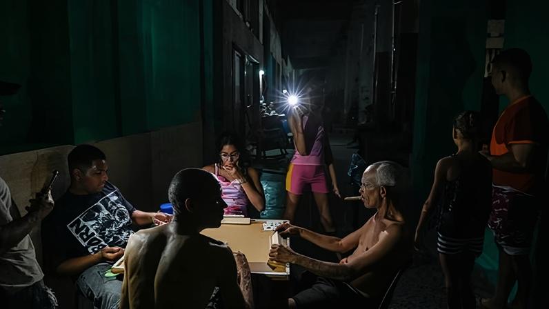 People play dominoes by the light of a cellphone flashlight during a blackout in the Centro Habana neighbourhood in Havana.