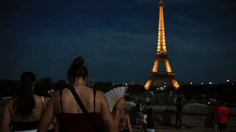 Uma mulher com um leque na Praça du Trocadéro, perto da Torre Eiffel, enquanto as temperaturas aumentam em Paris durante uma segunda onda de calor que afeta grande parte da França, em 20 de junho de 2026.