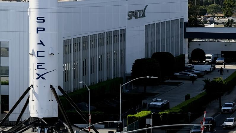 Traffic near a SpaceX Falcon 9 rocket displayed outside a Space Exploration Technologies Corp facility in Hawthorne, California