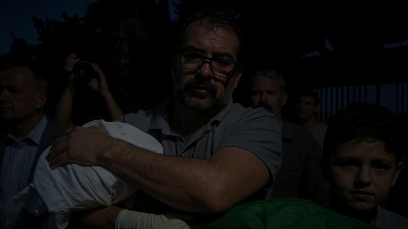 Fahd Abu Haikal carries the body of his seven-month-old son Sam, who was killed on Friday.