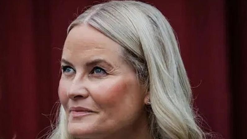 Crown Princess Mette-Marit wearing a breathing tube connected to an oxygen device