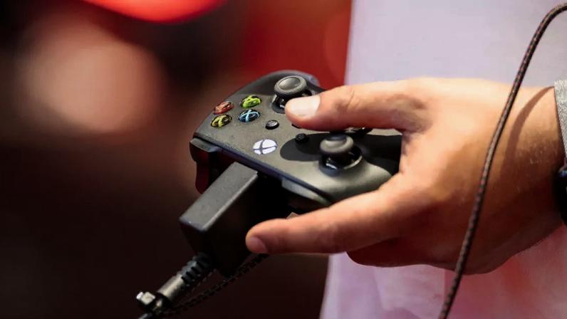 Visitante utilizando participante usa um controle do Xbox durante a Gamescom 2025