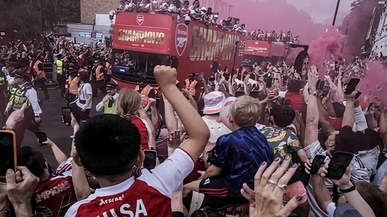 ‘The connection between fan and club runs deep’: Arsenal fans cheer their team during the street parade through north London on Sunday.