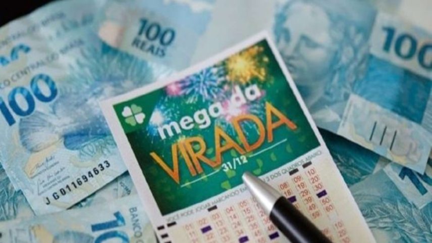 Imagem colorida de cartela de aposta da mega da virada acima de notas de R$ 100 - Metrópoles