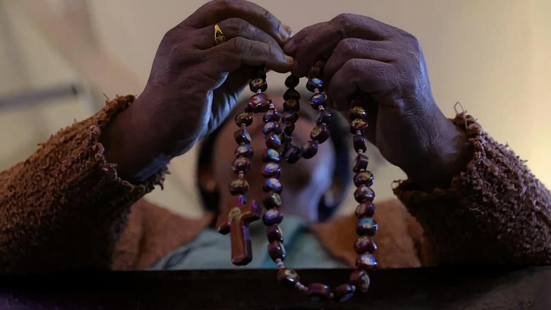 Fiel segura um rosário: pedidos de oração (Foto: EFE)