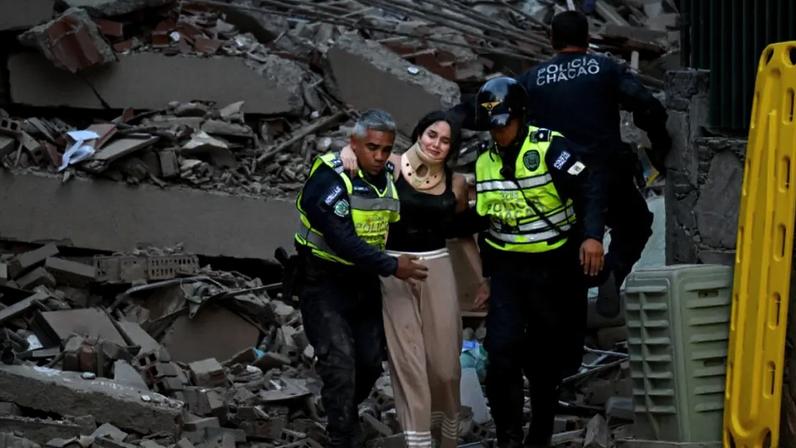 Agentes da polícia municipal ajudam uma vítima ferida de um edifício que desabou após um terremoto ocorrido em Caracas, em 24 de junho de 2026.