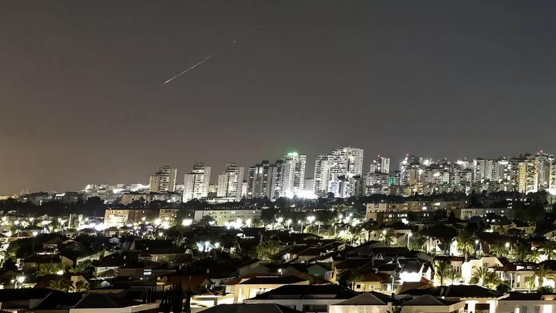 Um rastro de luz ilumina o céu durante um ataque de míssil do Irã em direção a Israel, visto de Ashkelon, Israel, em 7 de junho de 2026.