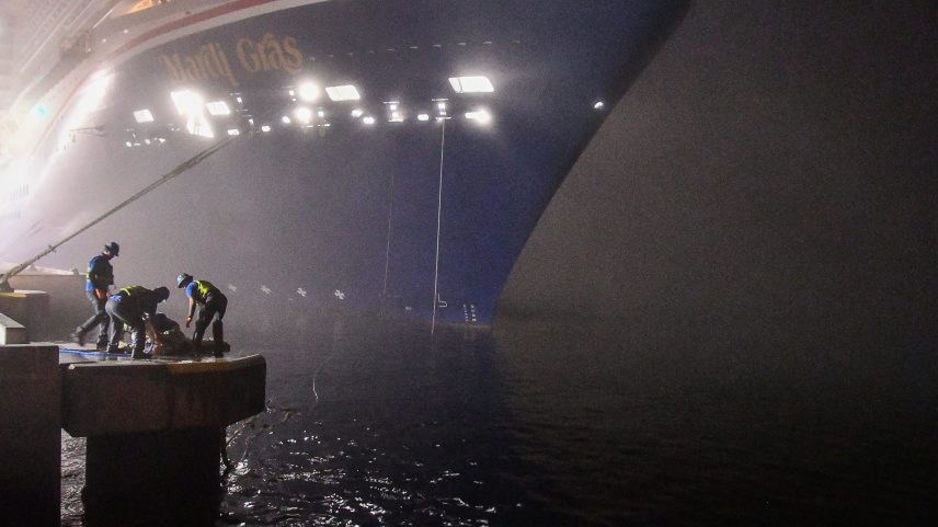 Workers secure the lines as Carnival Mardis Gras docks at Terminal 3. Cruise ships came into Port Canaveral blaring their fog horns on an extremely foggy morning.