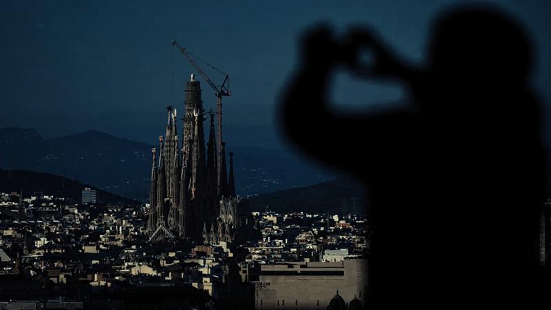 Um turista tira fotos da Basílica da Sagrada Família, que se torna a igreja mais alta do mundo em 10 de junho de 2026 após a instalação de uma seção de sua torre central, em Barcelona, na Espanha. Imagem de 30 de outubro de 2025.