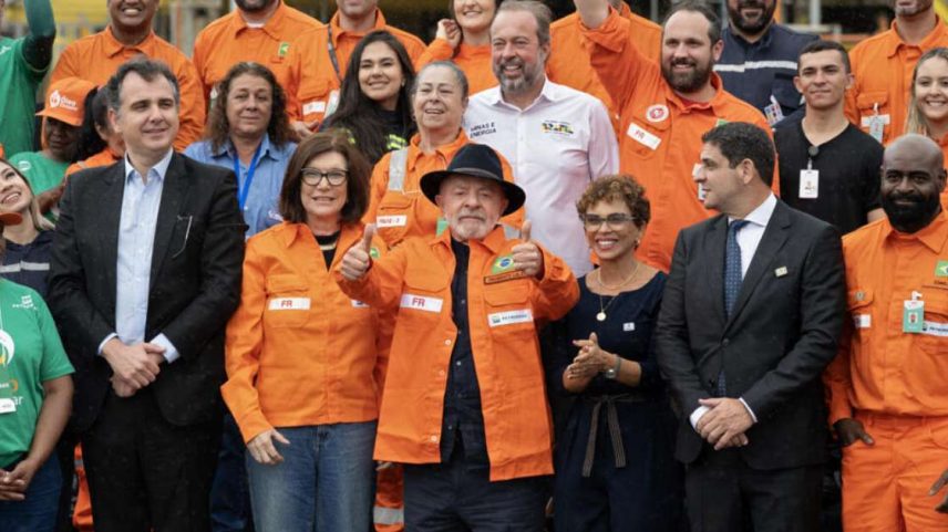O presidente Luiz Inácio Lula da Silva (de chapéu) posa ao lado da presidente da Petrobras, Magda Chambriard (centro-esquerda), políticos e funcionários em um evento realizado para anunciar os investimentos da Petrobras na refinaria Gabriel Passos em Betim, Minas Gerais, Brasil, em 20 de março de 2026.