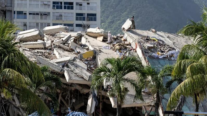 Um prédio desabado é visto a partir do acampamento-base do Regimento de Treinamento e Intervenção da Segurança Civil Francesa (UIISC 7), no complexo Karting La Guaira, em Caraballeda (estado de La Guaira, Venezuela), em 27 de junho de 2026, enquanto a equipe auxilia nas operações de resgate após terremotos (MIGUEL MEDINA / POOL/AFP)