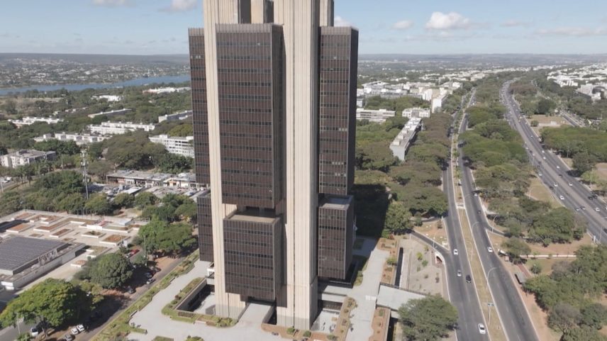 Vista aérea do prédio do Banco Central em Brasília, com avenidas e áreas verdes ao redor