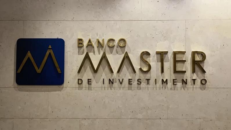 Fachada interna com logo dourado do Banco Master de Investimento em parede clara.