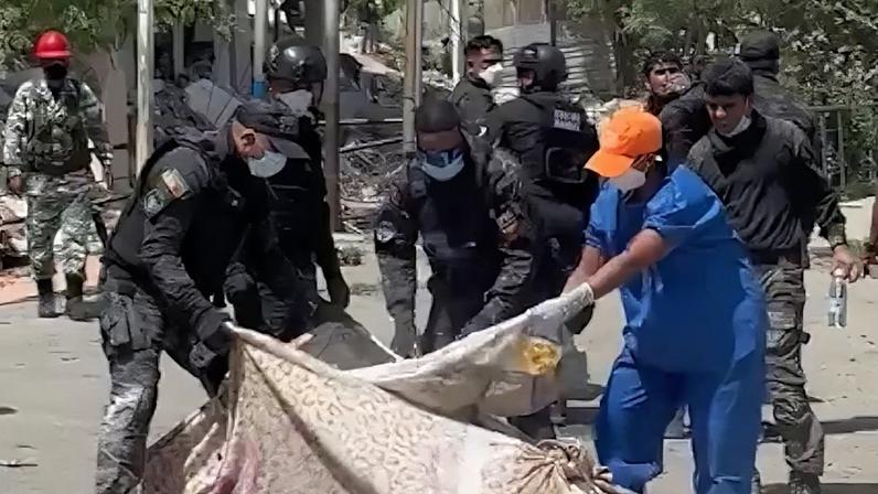 Trabalho de bombeiros e policiais na Venezuela encontra dificuldades diante do elevado número de vítimas. Na imagem, policiais jogam cal em corpo