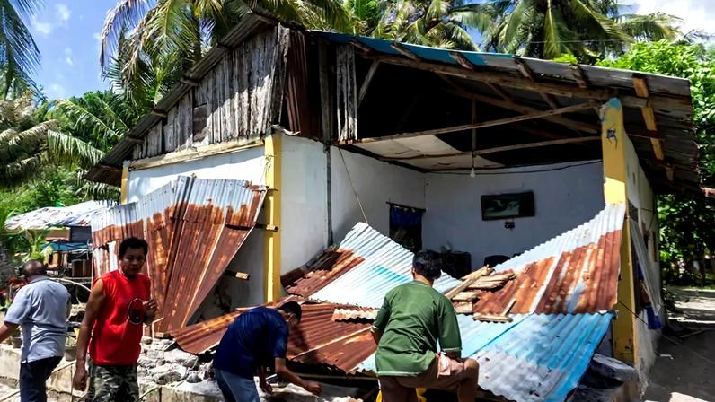 Pessoas recolhem seus pertences de uma casa danificada após um terremoto na costa da ilha de Mindanao, no sul das Filipinas, que também foi sentido em Tabukan do Norte, na regência das Ilhas Sangihe, província de Sulawesi do Norte, Indonésia, em 8 de junho de 2026. REUTERS/Stenly Pontolawokang