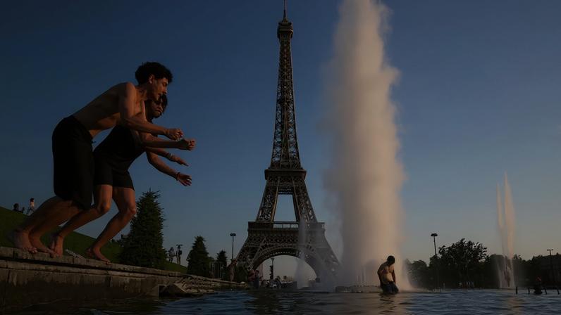 Pessoas se refrescam na Fonte do Trocadéro, ao lado da Torre Eiffel, em Paris, em meio a uma onda de calor que atinge grande parte da França, 22 de junho de 2026. REUTERS/Abdul Saboor