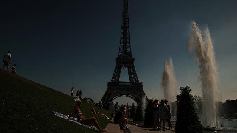 Pessoas se refrescam perto da Torre Eiffel, na França, em meio à onda de calor.