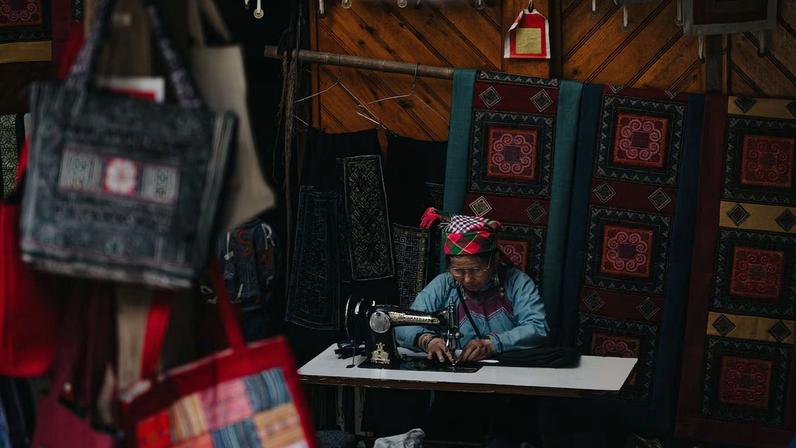 A vibrant scene of a traditional textile market in Lào Cai, showcasing handcrafted fabric and bags.