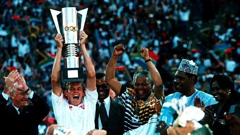 Neil Tovey, da África do Sul, capitão da seleção campeã da Copa Africana de Nações de 1996, comemora com o troféu após recebê-lo do presidente Nelson Mandela - (Gallo Images/Getty Images)