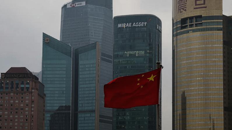 Vista de edifícios e da bandeira chinesa em Xangai, China, em 16 de março de 2026