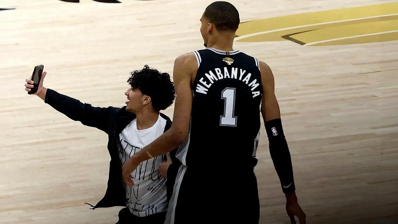 During Game 1 of the Spurs-Knicks NBA Finals, a fan ran onto the court to attempt a selfie with Victor Wembanyama.